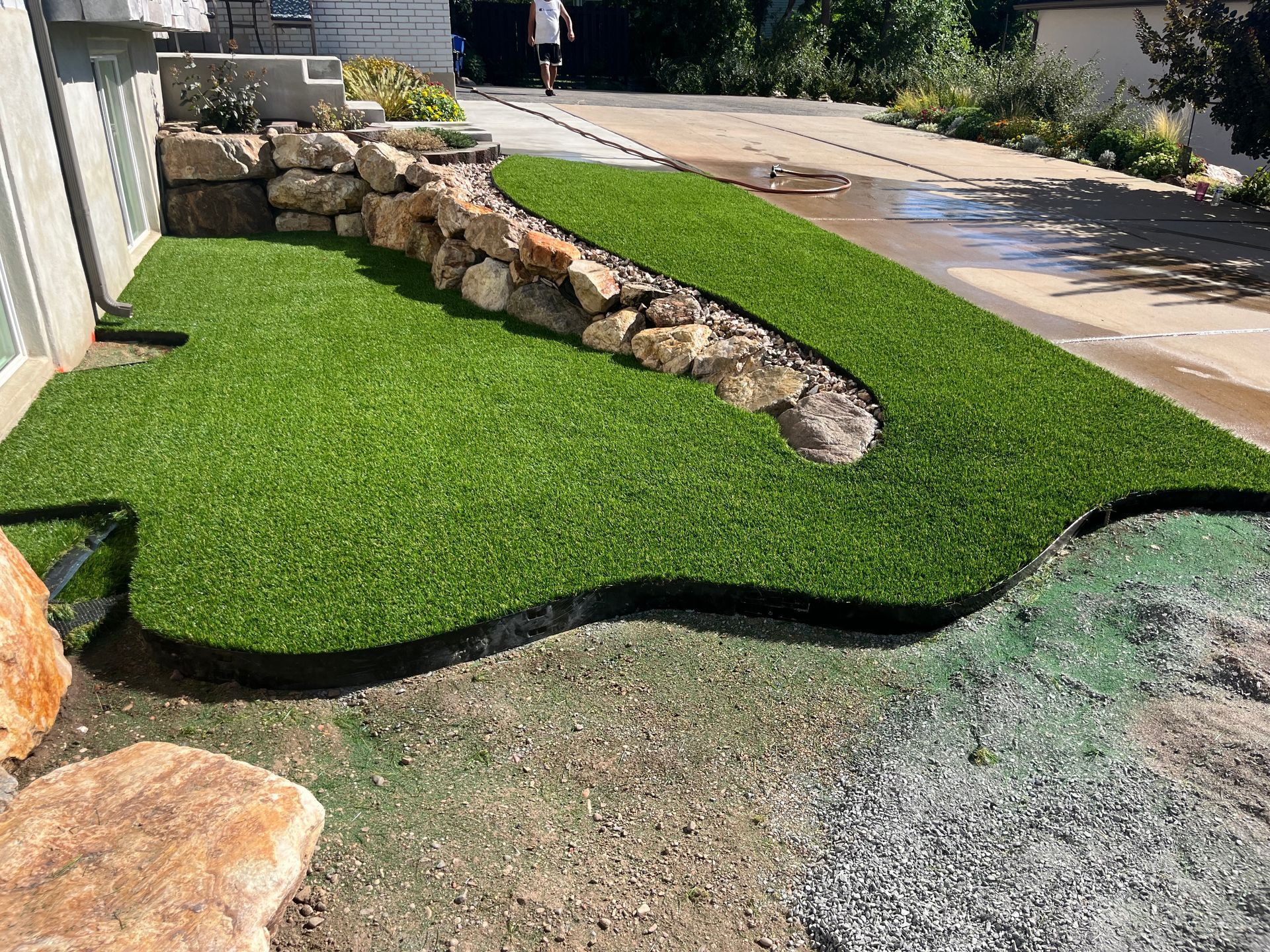 Artificial turf landscaping with a rock water feature.