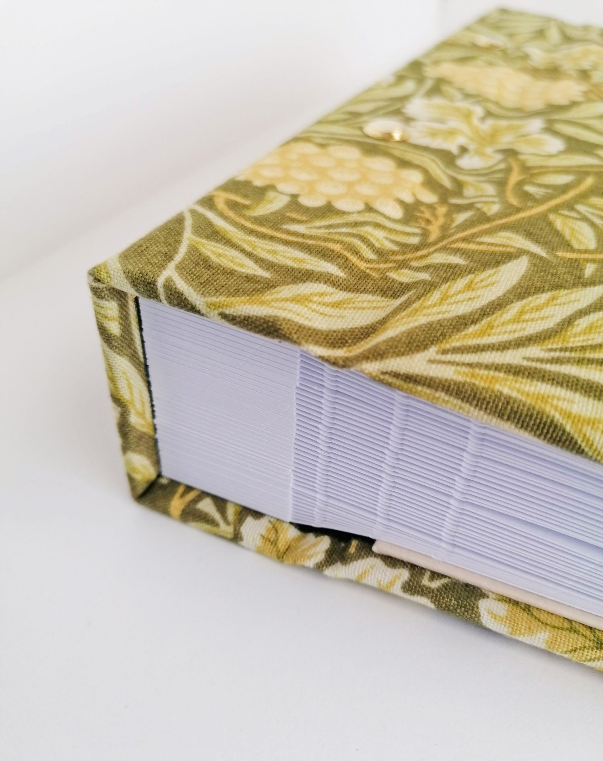 The image shows a close up detail of the decorative album and how the pages are stacked and bound together using golden brass screw posts.