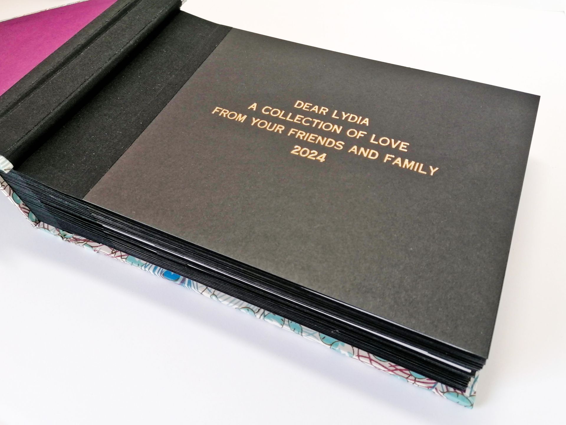 The image shows The first page of the album and gold lettering which reads Dear Lydia a collection of love from your friends and family 2024.
