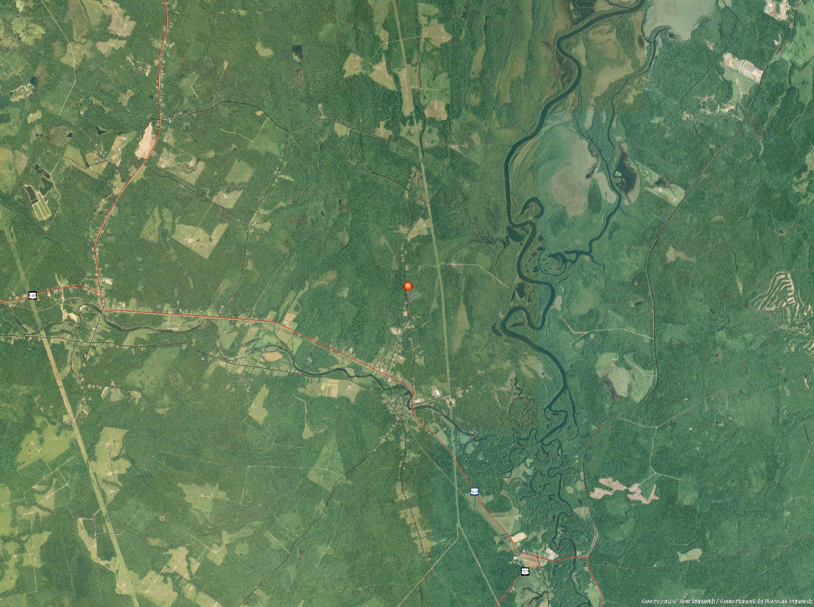 An aerial view of a river surrounded by trees and fields