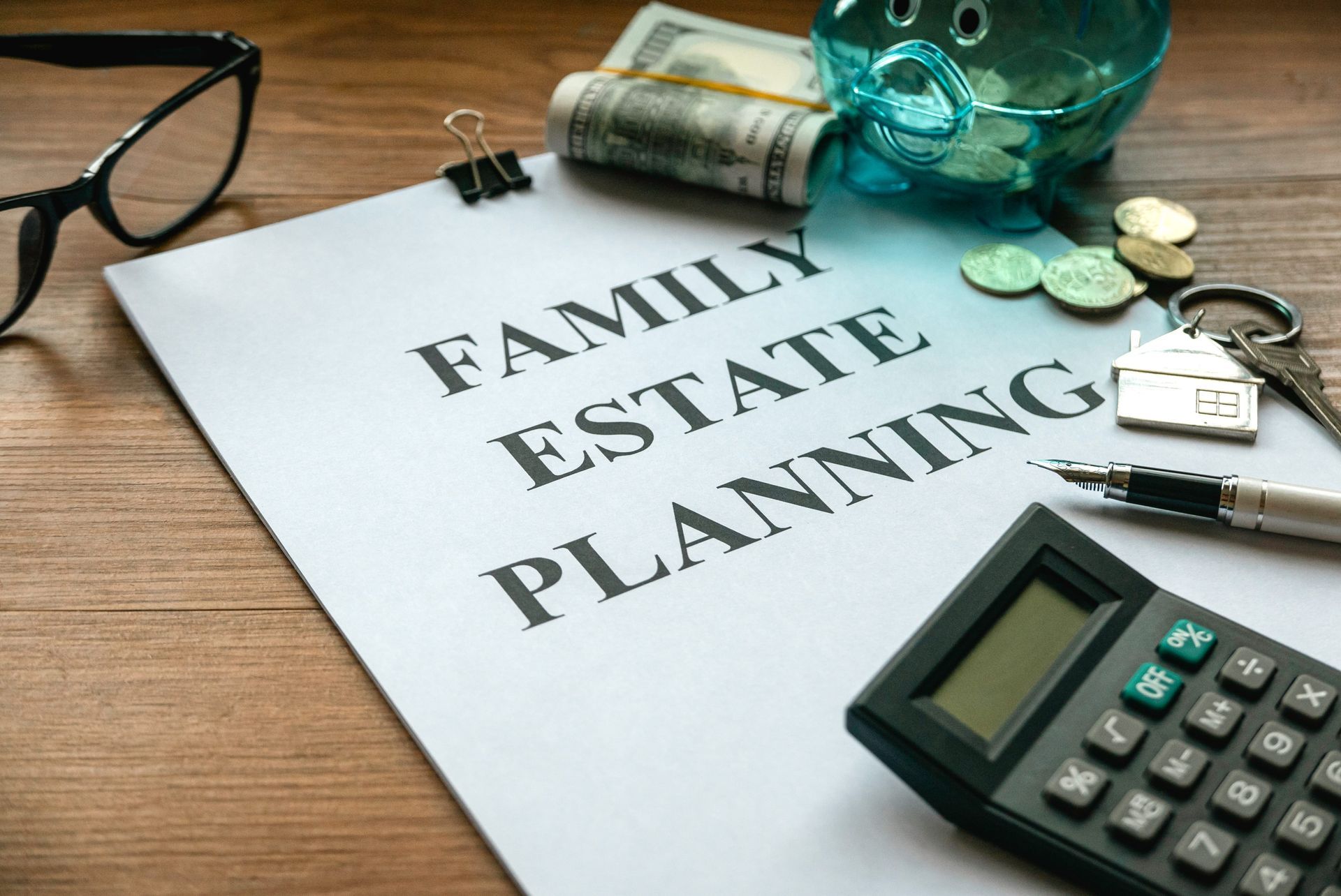 Family estate planning paperwork on a desk with calculator, glasses, keys, and coins