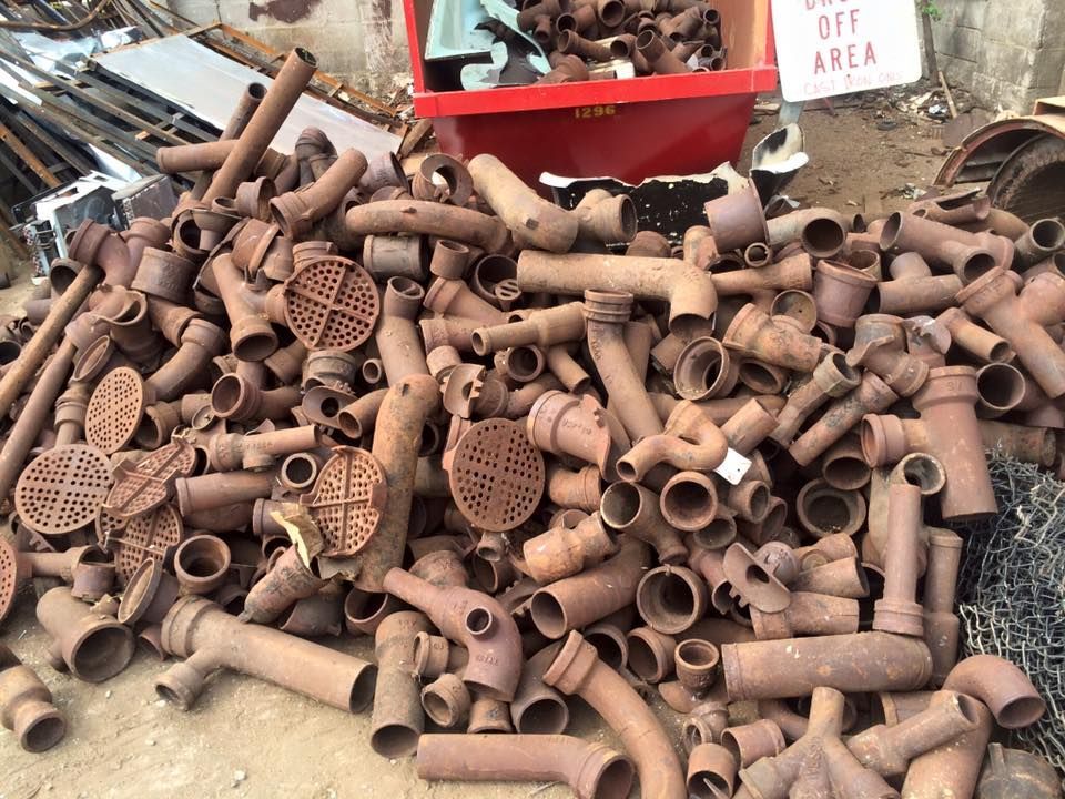 A pile of rusty pipes with a sign that says off area