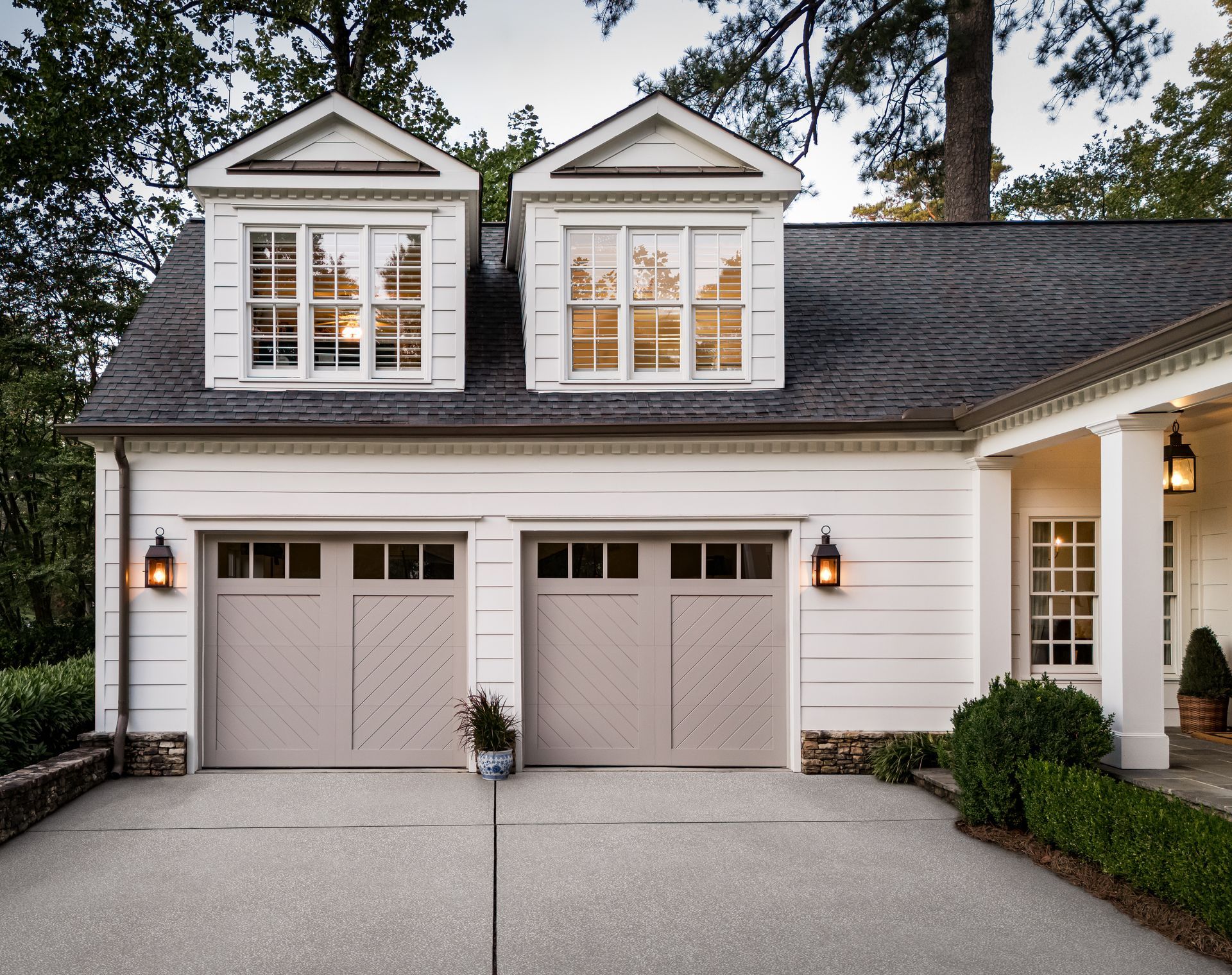 Chevron-panel carriage style garage doors on a white dormered garage