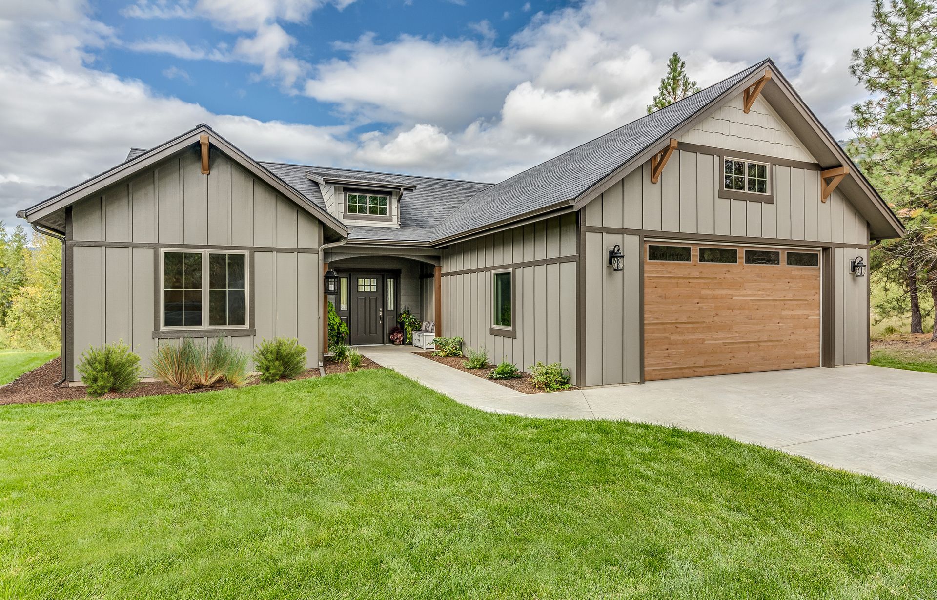 Natural wood-plank modern garage door on a craftsman home