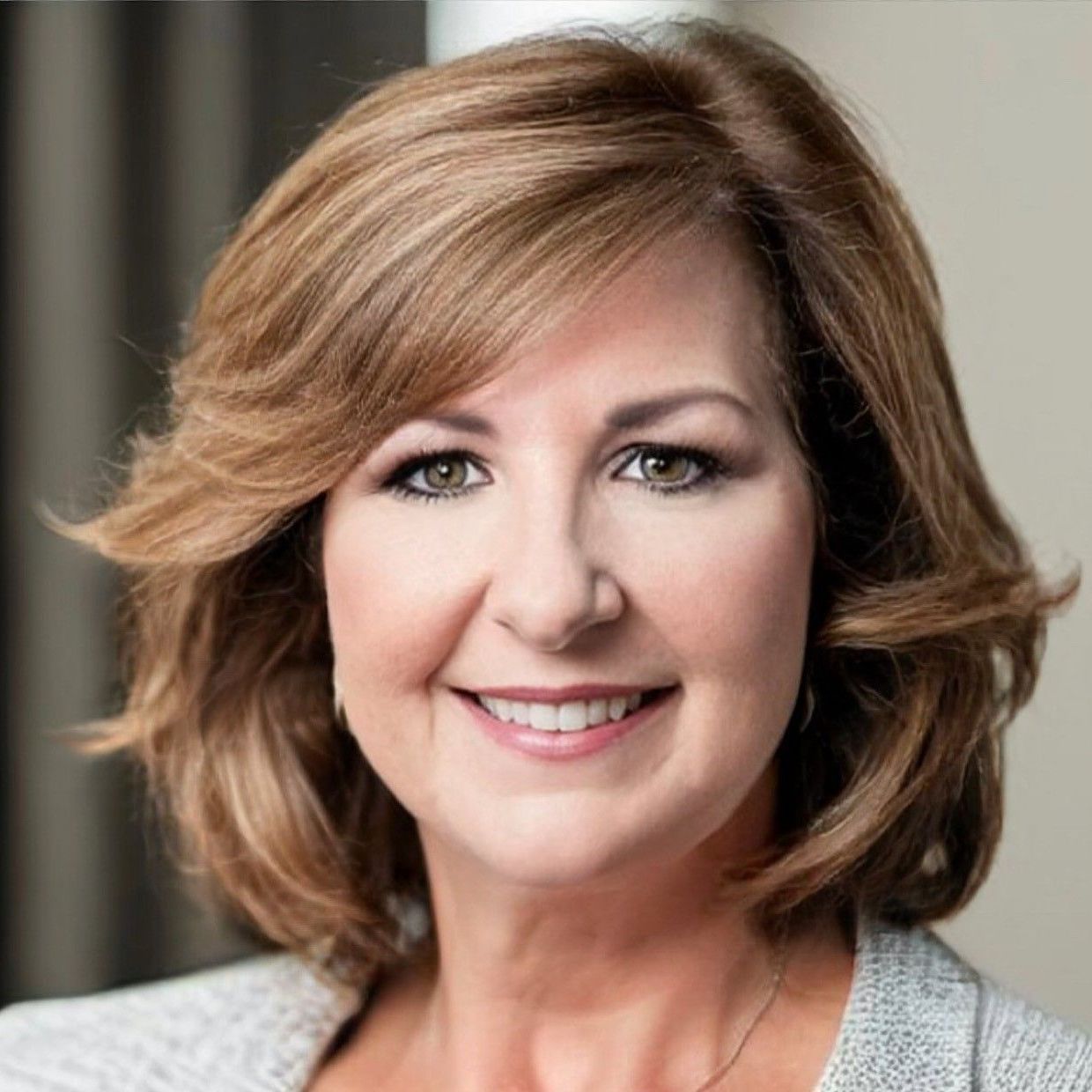 A woman with short brown hair is smiling for the camera.