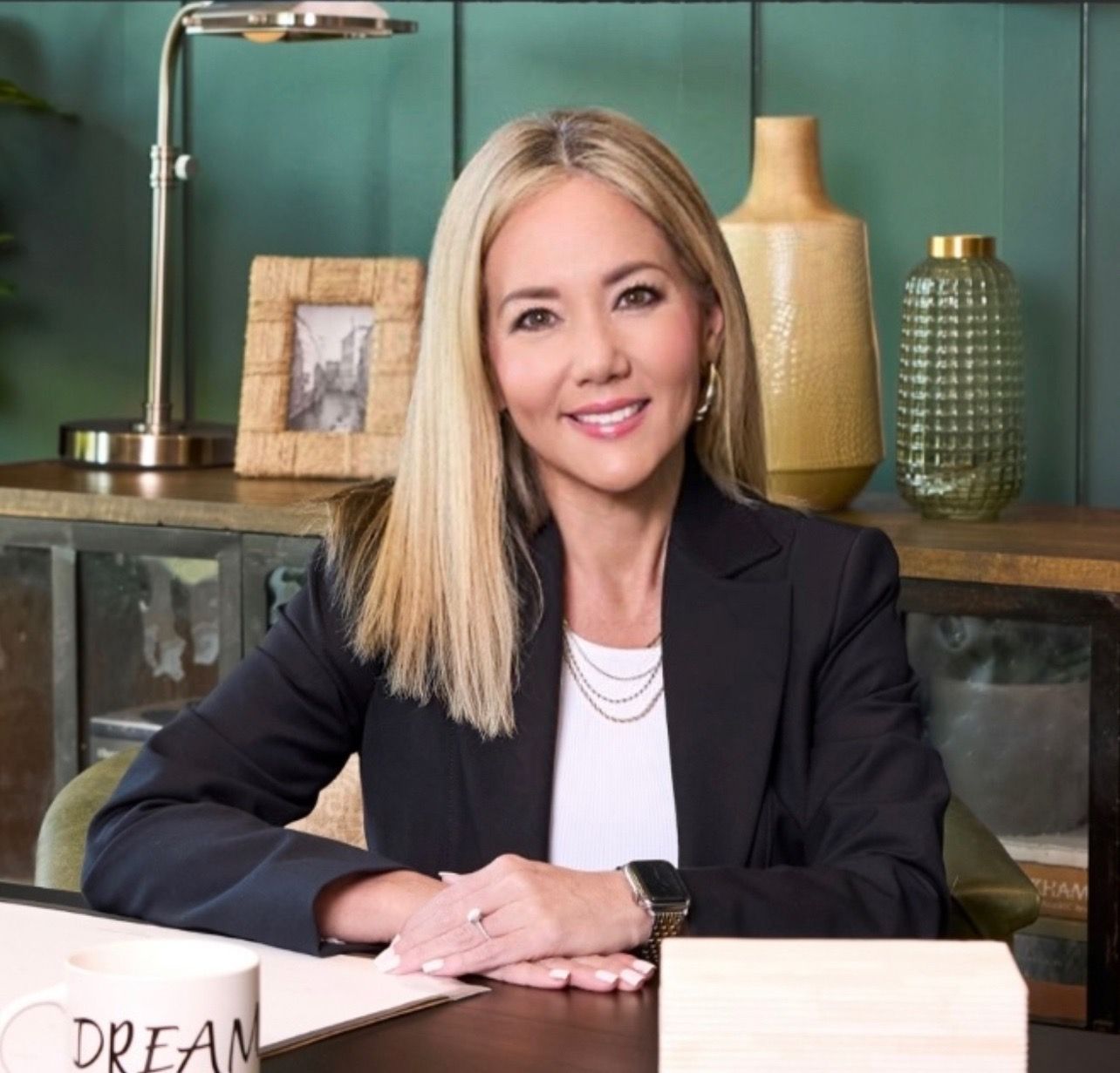 A woman is sitting at a desk with a sign that says dream
