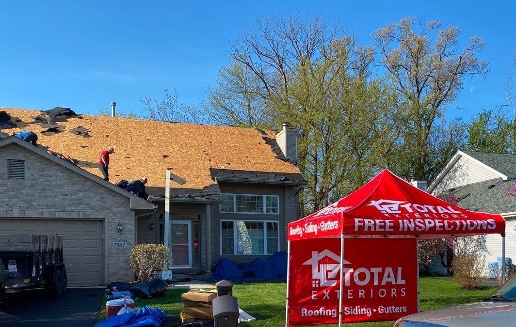 A red tent is sitting in front of a house.