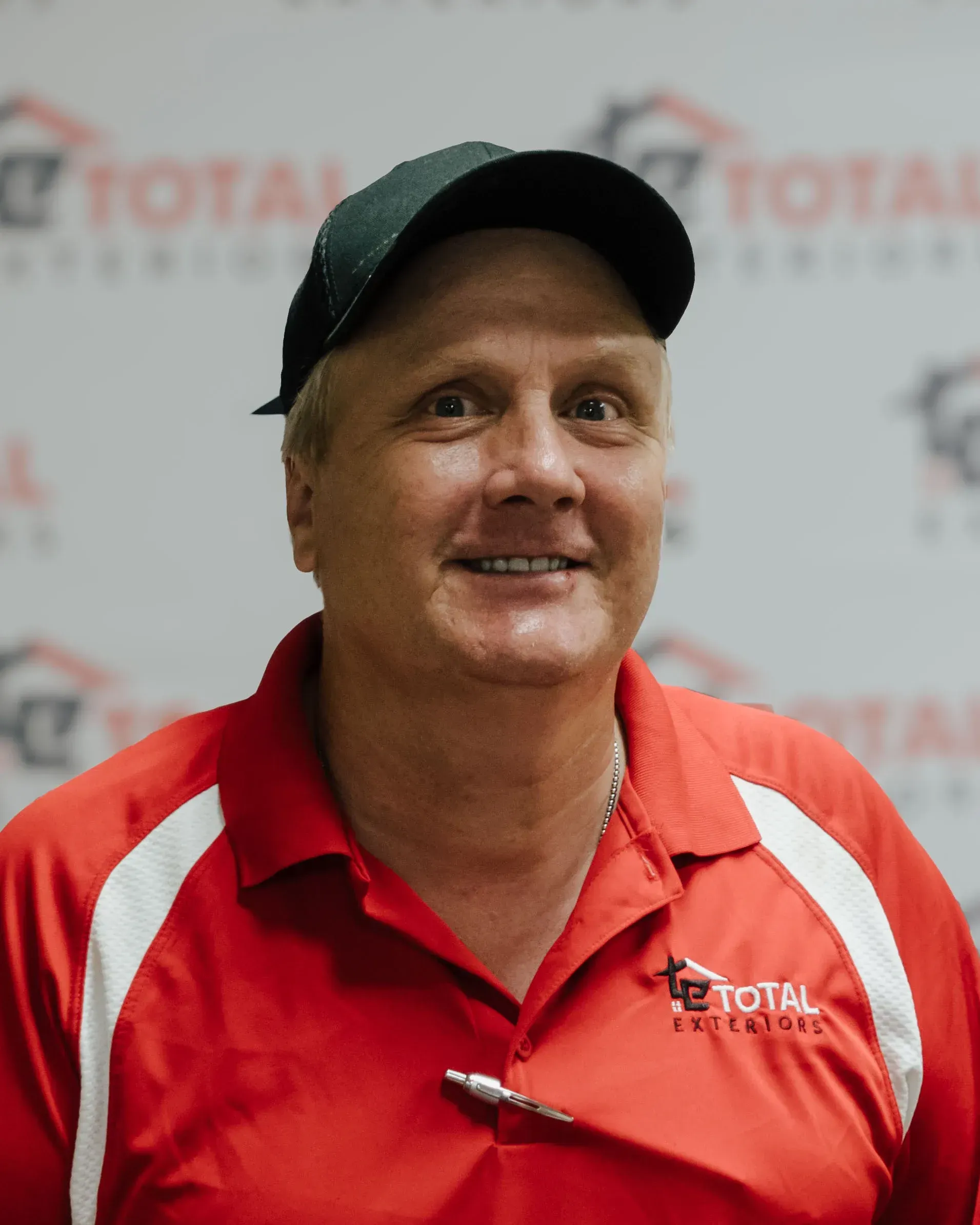 A man wearing a red shirt with the word total on it