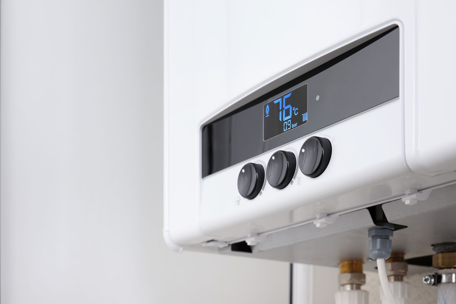 White wall-mounted boiler with digital display showing 