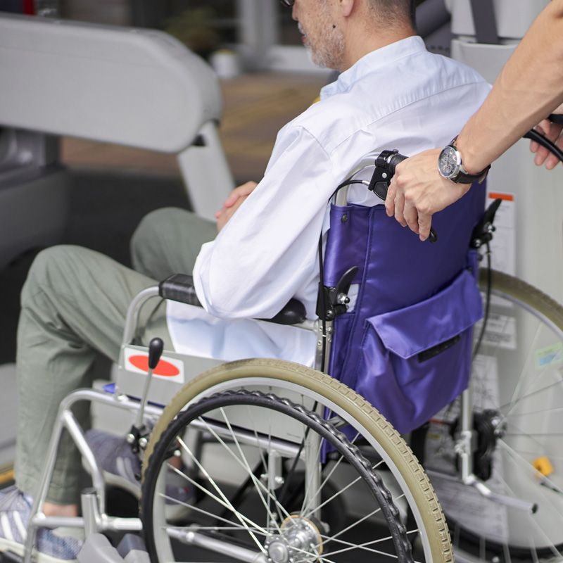 Elderly patient assisted into wheelchair for safe medical transportation service