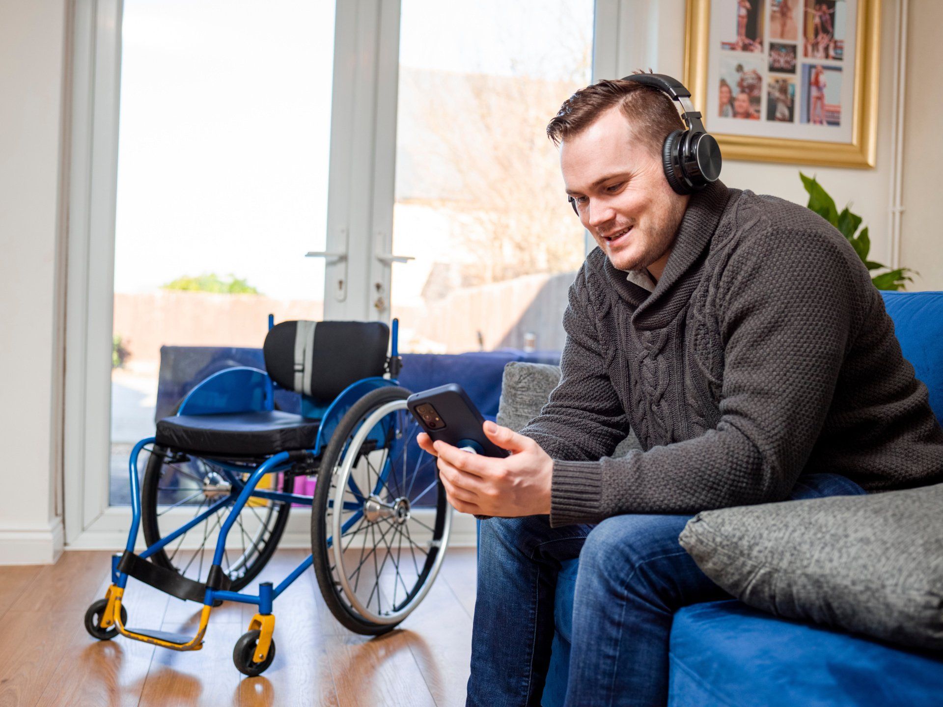 man listening to music by his blue accessorized wheelchair