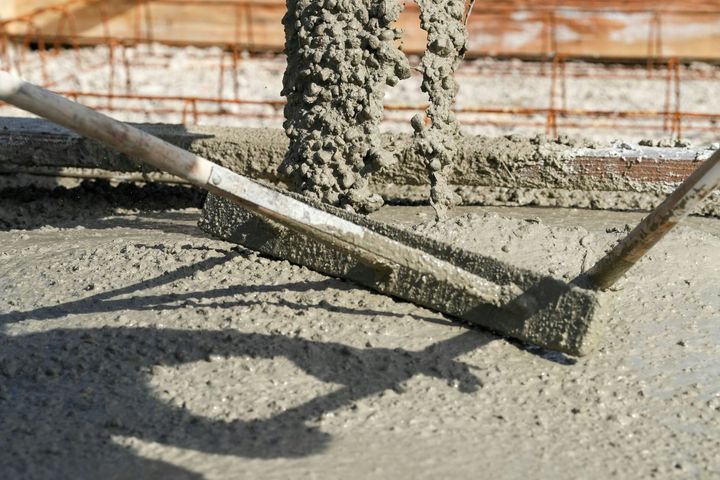 Concrete trowel smoothing wet cement on a construction site