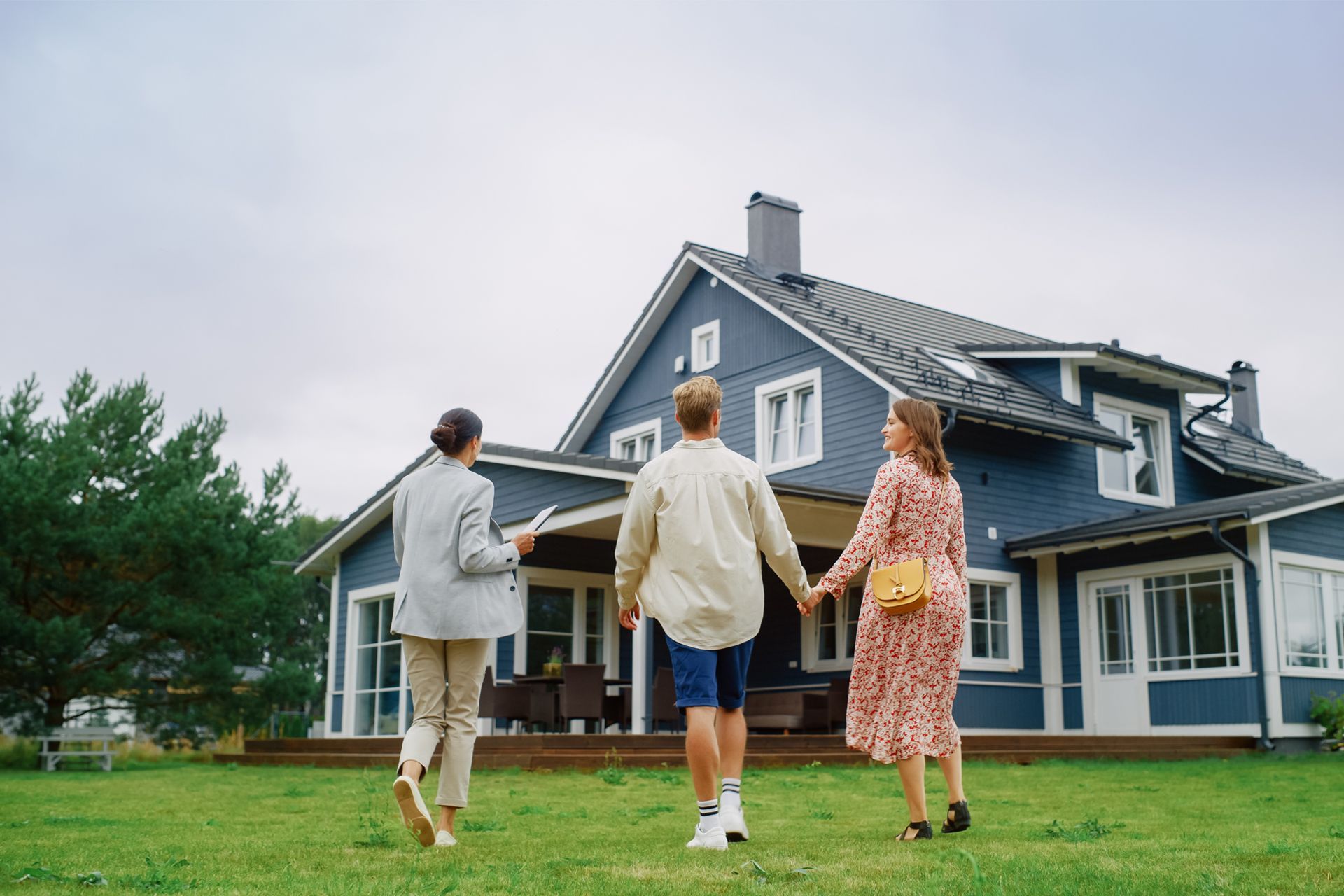 Couple Outside Their New House With Insurance Agent