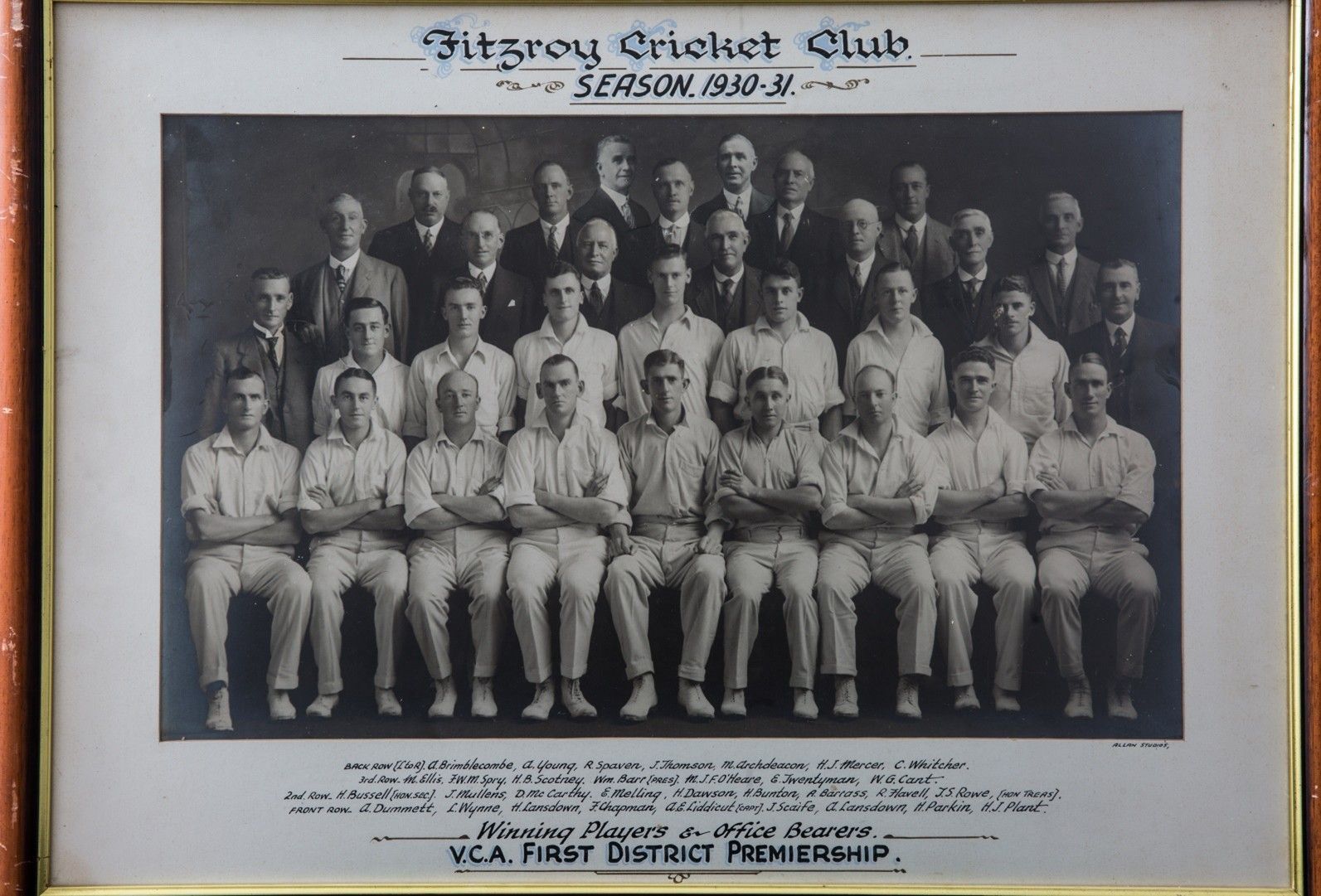 Fitzroy Cricket Club team photo in black and white, with players and captions in a framed display