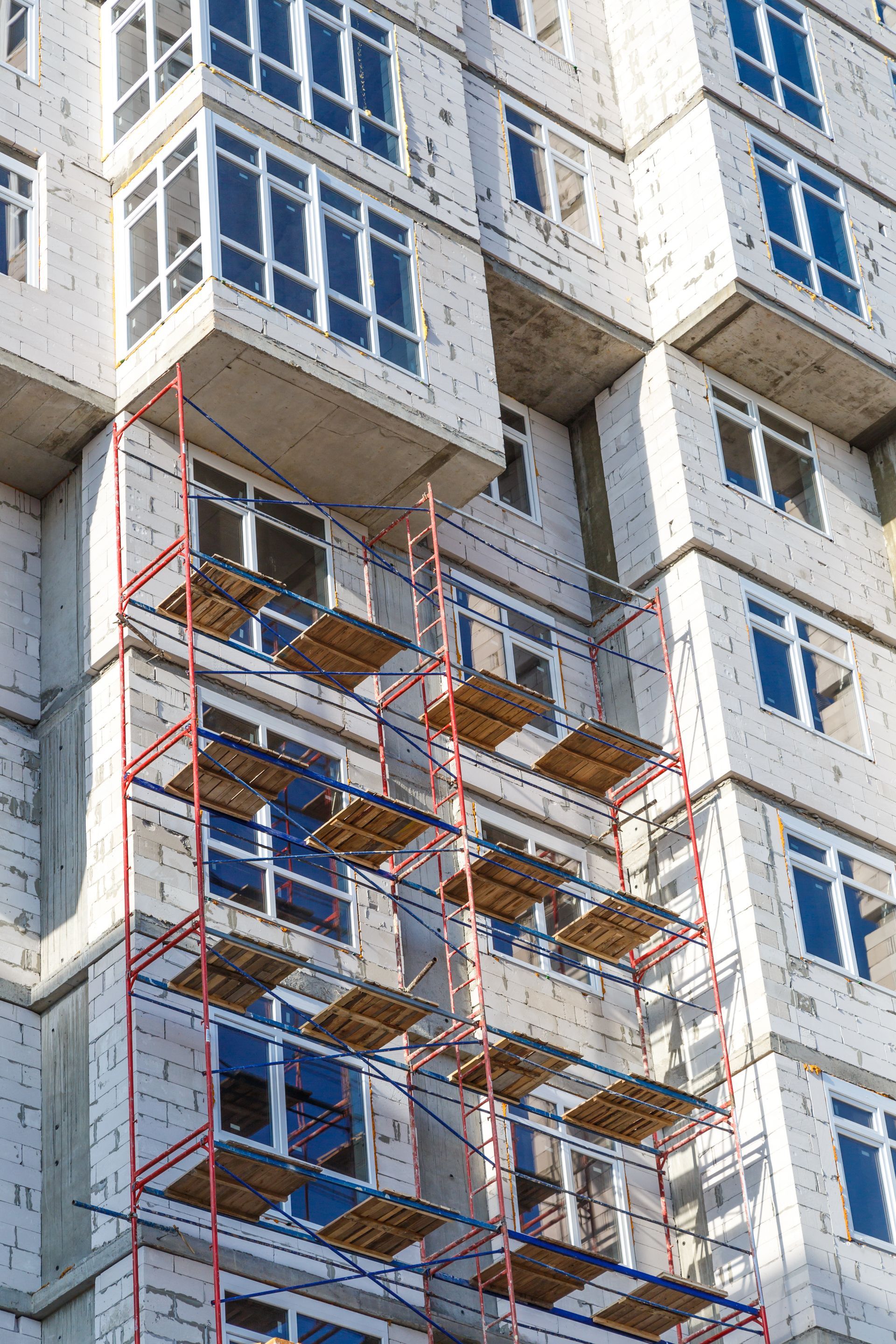 Frame scaffolding set up along a multi-story building exterior for construction and façade work.