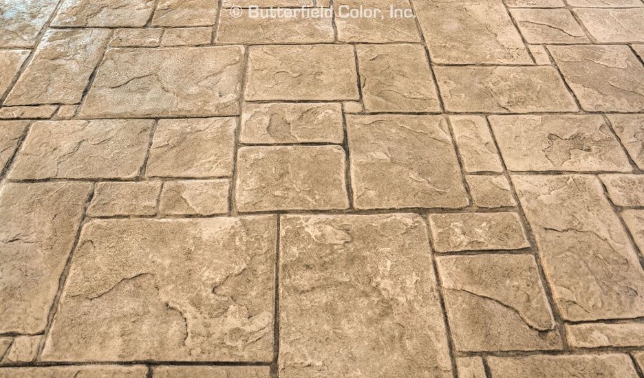 Stamped concrete surface with textured stone pattern created using concrete stamp mats.