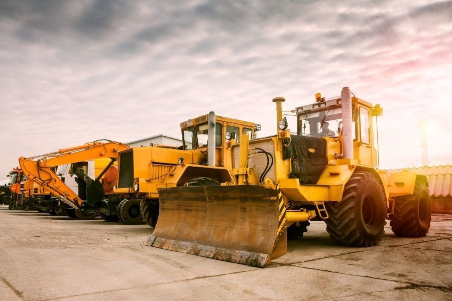 Heavy construction equipment lined up on jobsite, including dozers and excavators.