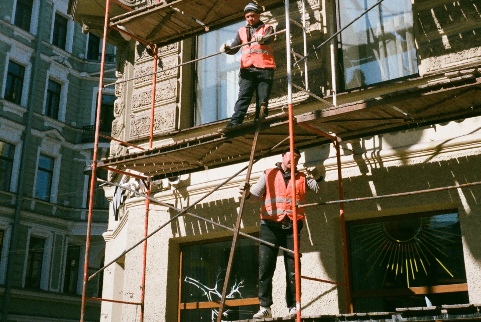 Construction crew working on exterior scaffolding during building restoration.