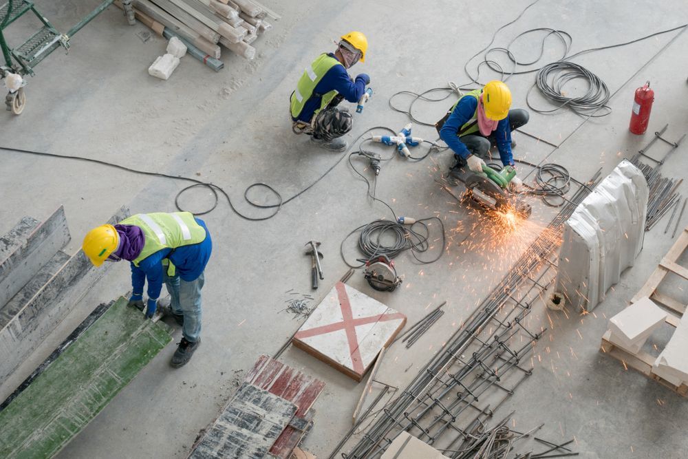 A group of construction workers are working on a concrete construction site, using concrete vs. steel.