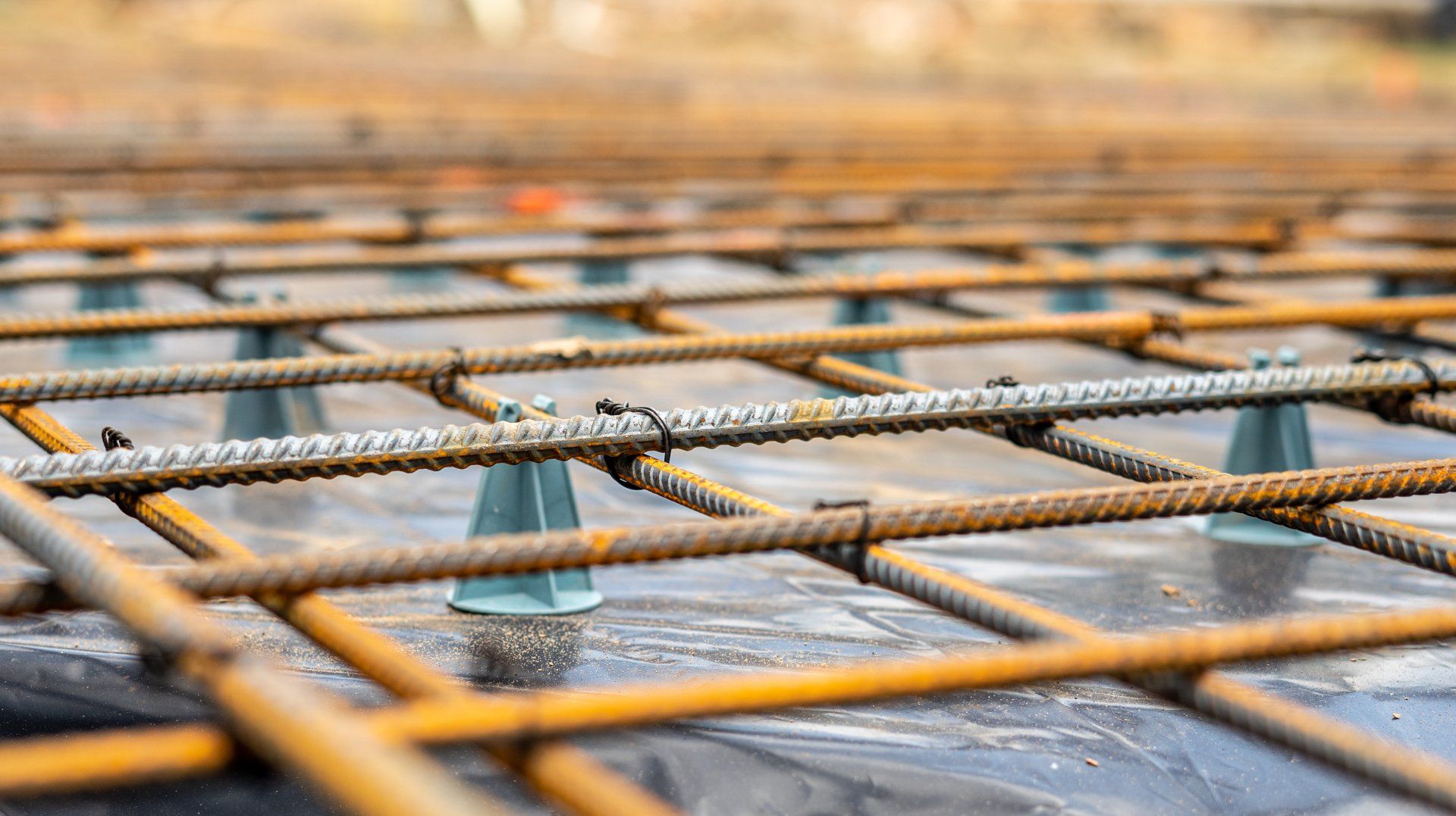 Steel rebar grid elevated on chairs over vapor barrier for reinforced concrete slab installation