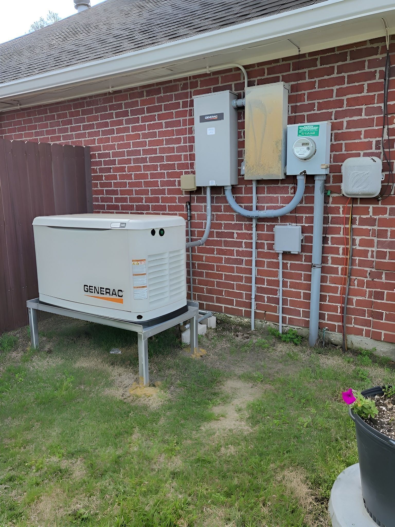 A blue house with a generator in the backyard.