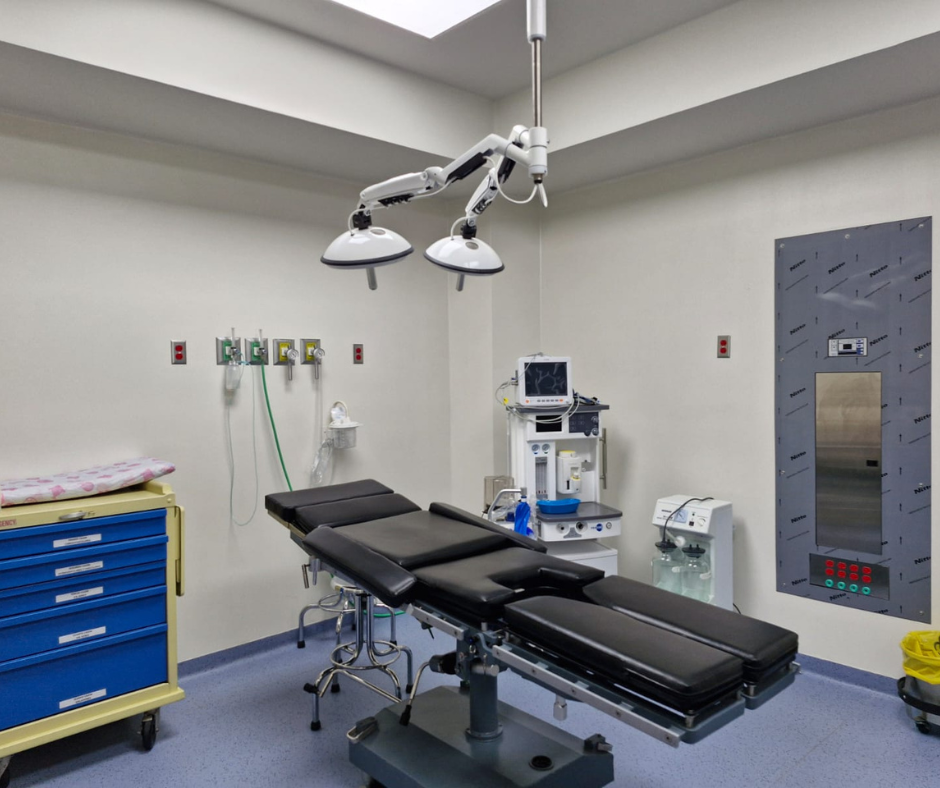 Quirófano con mesa quirúrgica, equipamiento médico e iluminación cenital.