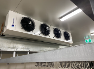 A Large White Industrial Cooler With Four Black Fans Hangs From A Ceiling — Refrigeration & Air Conditioning in Jewells, NSW