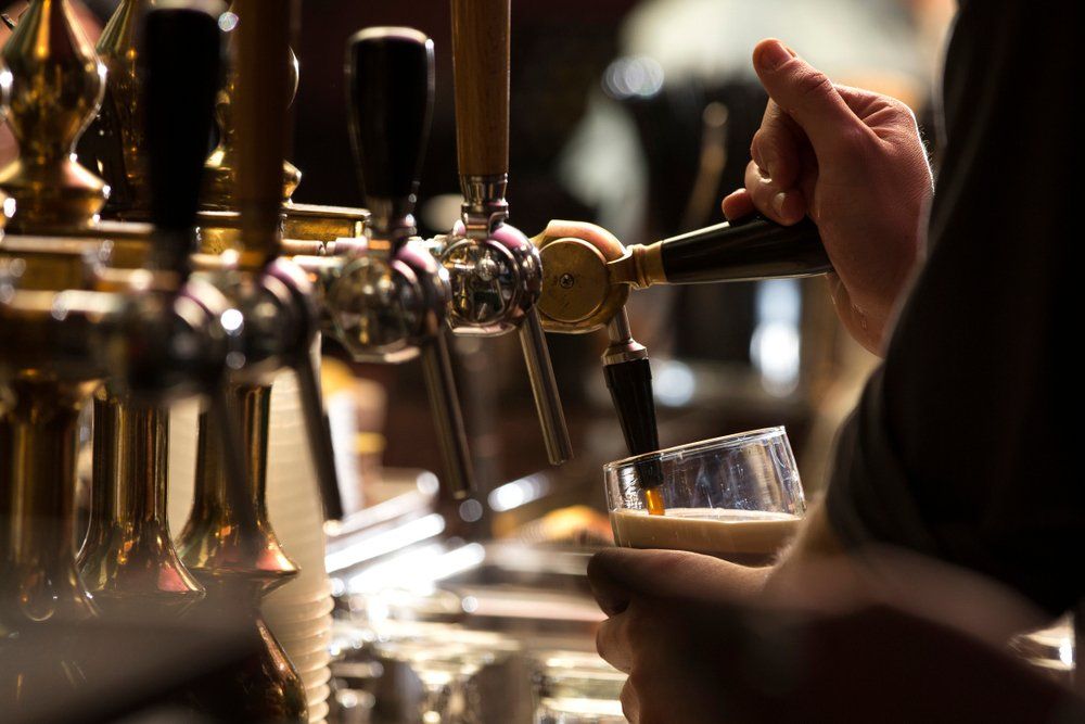 Close Up of a Bartender Pouring a Dark Stout Beer — Refrigeration & Air Conditioning in Jewells, NSW