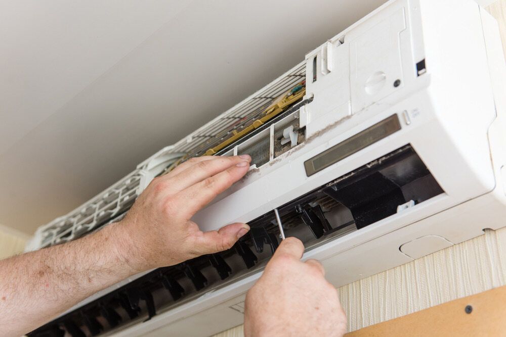 A White Air Conditioner Being Opened — Refrigeration & Air Conditioning in Warners Bay, NSW