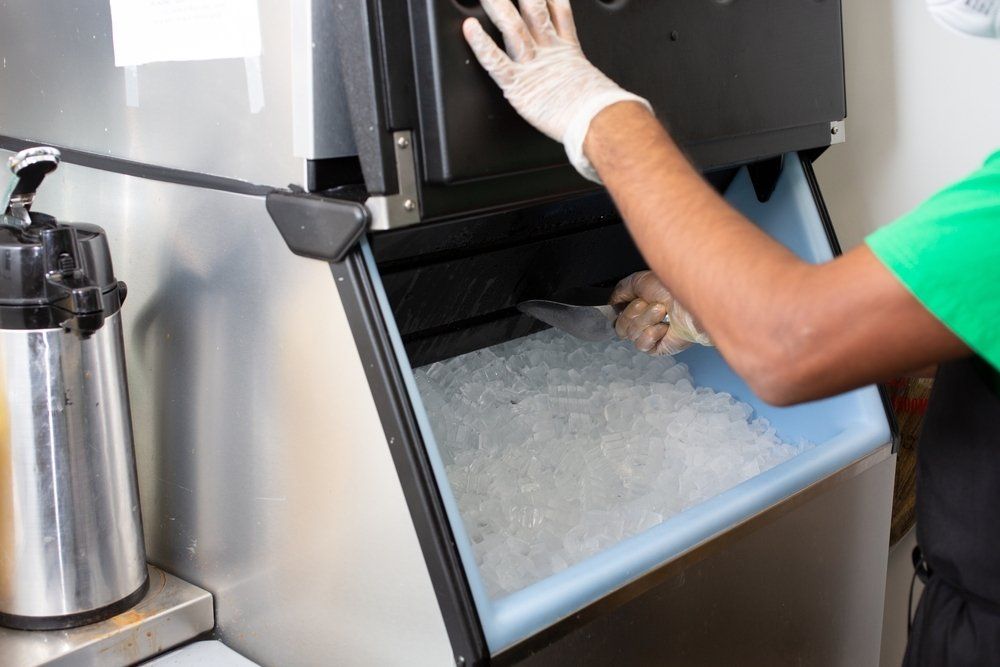 A View of an Employee Scooping Ice Out of an Ice Machine — Refrigeration & Air Conditioning in Jewells, NSW