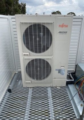 Fujitsu Air Conditioning Unit On A Metal Grate Platform — Refrigeration & Air Conditioning in Jewells, NSW