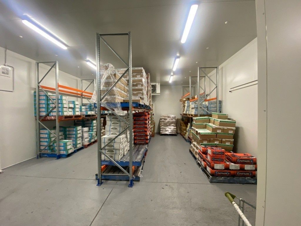 Warehouse Interior with Shelves Stacked with Food Products — Refrigeration & Air Conditioning in Jewells, NSW