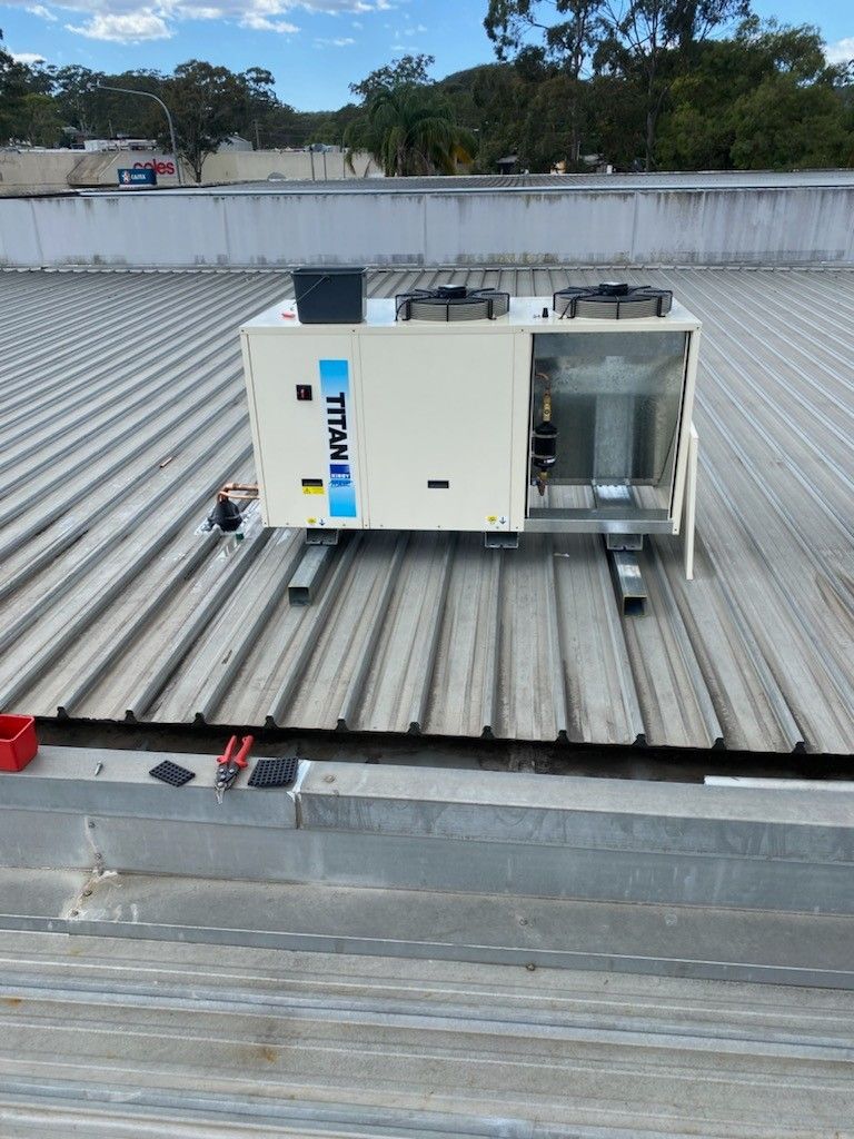 Air Conditioning Unit on A Corrugated Metal Roof, Outdoors — Refrigeration & Air Conditioning in Jewells, NSW