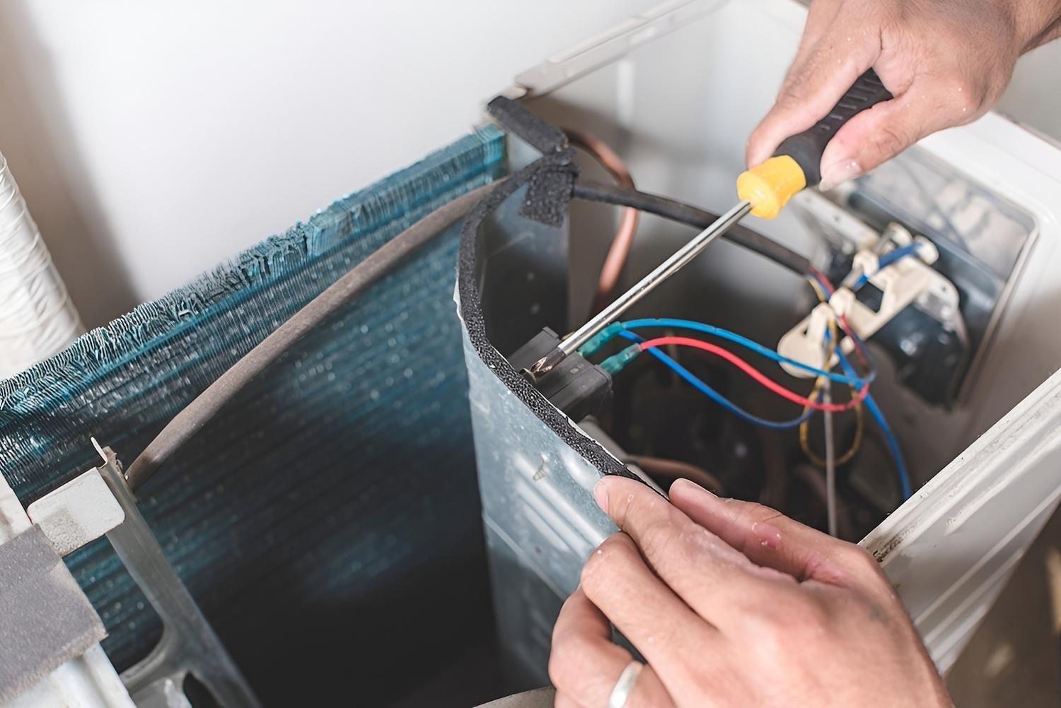 Person Using a Screwdriver on an Air Conditioning Unit — Refrigeration & Air Conditioning in Port Stephens, NSW