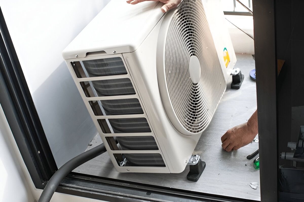 Person Installing an Air Conditioning Unit, White Exterior — Refrigeration & Air Conditioning in Warners Bay, NSW