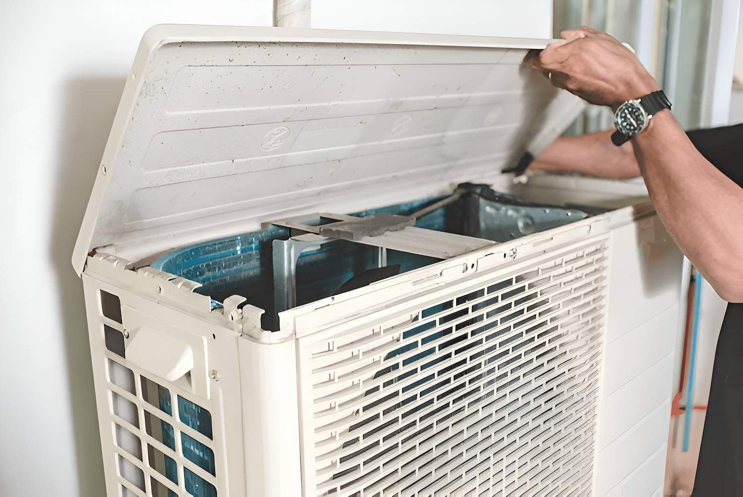 Person Opening the Top of an Outdoor Air Conditioning Unit — Refrigeration & Air Conditioning in Newcastle, NSW