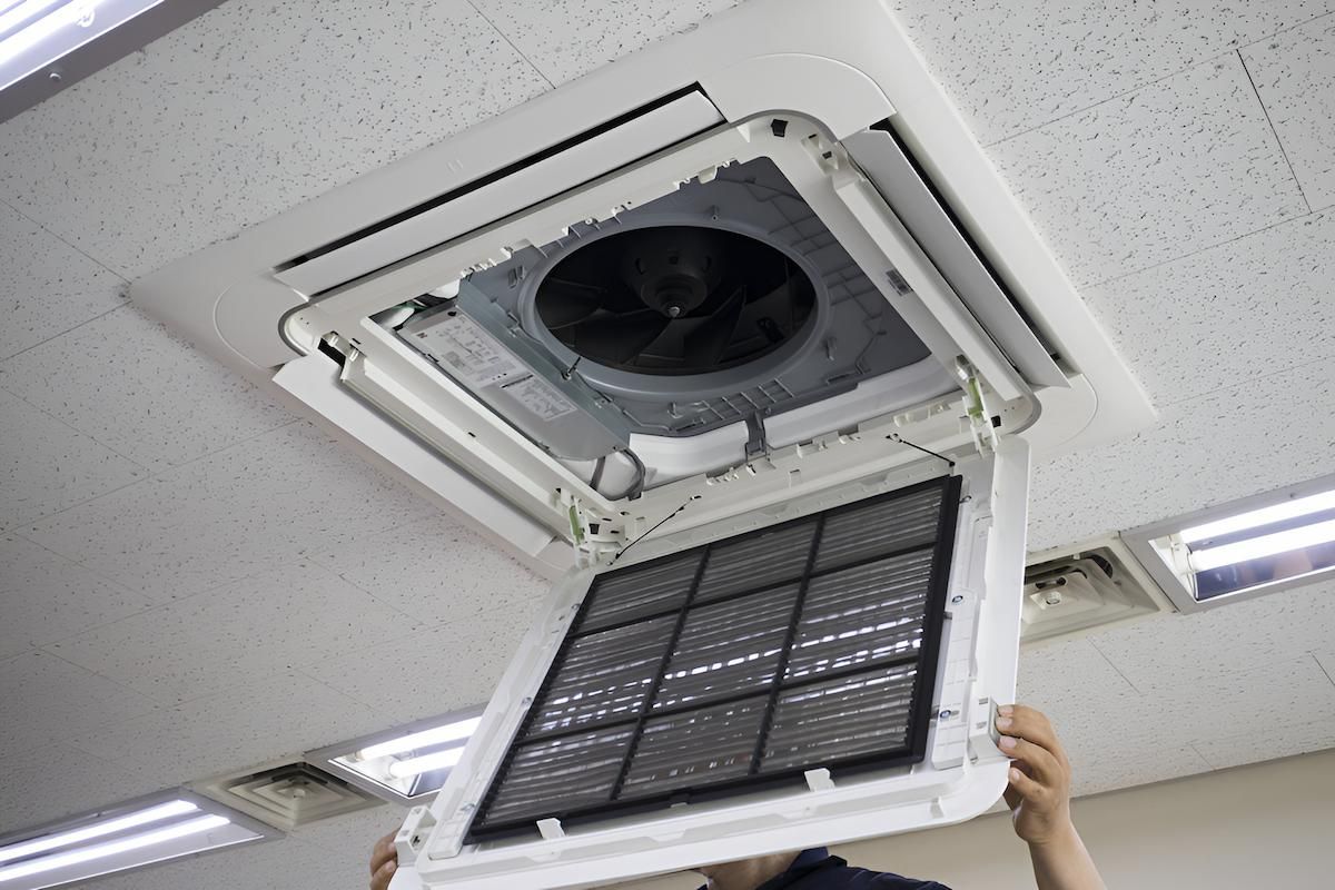 Person Removing a Filter From a Ceiling-mounted Air Conditioner — Refrigeration & Air Conditioning in Newcastle, NSW
