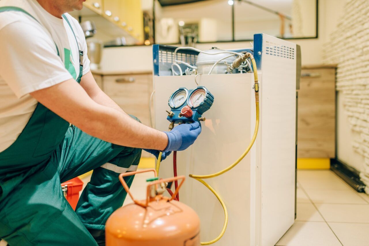 Technician Repairing a Refrigerator, Attaching Gauges and Hoses — Refrigeration & Air Conditioning in Newcastle, NSW