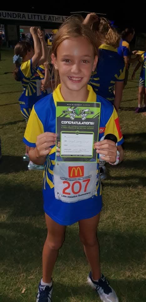 Girl in blue and yellow sports uniform holding a Laserzone Sunshine Coast achievement award, smiling.
