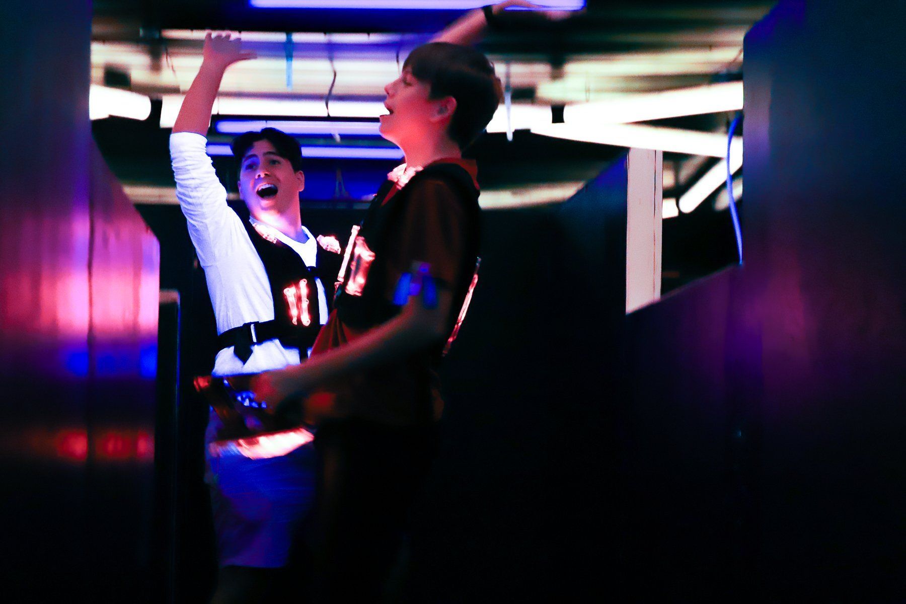 Young adults cheering while playing laser tag