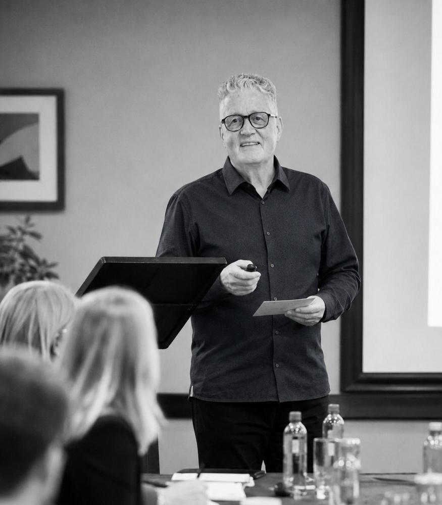 A mature website designer at Pivot2Connect is doing a presentation for a company.