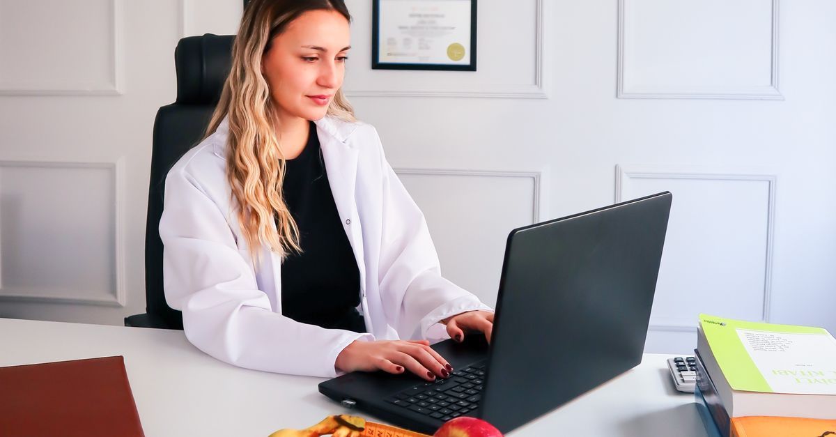 A coach working on their directory profile at a bright desk