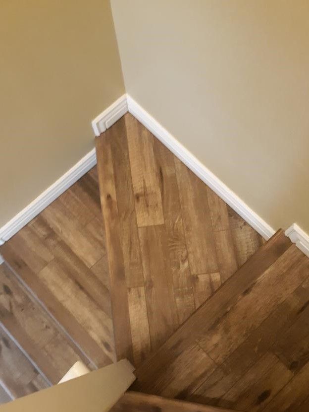 A room with a wooden floor and two windows.
