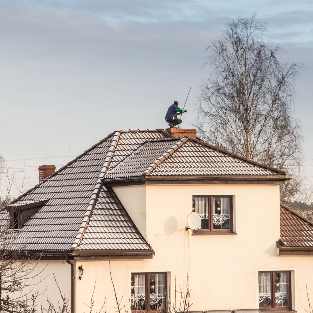 Person fishing from the roof of a house.