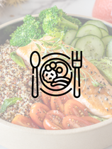 A bowl of food with broccoli , carrots , tomatoes and cucumbers with a fork and spoon.