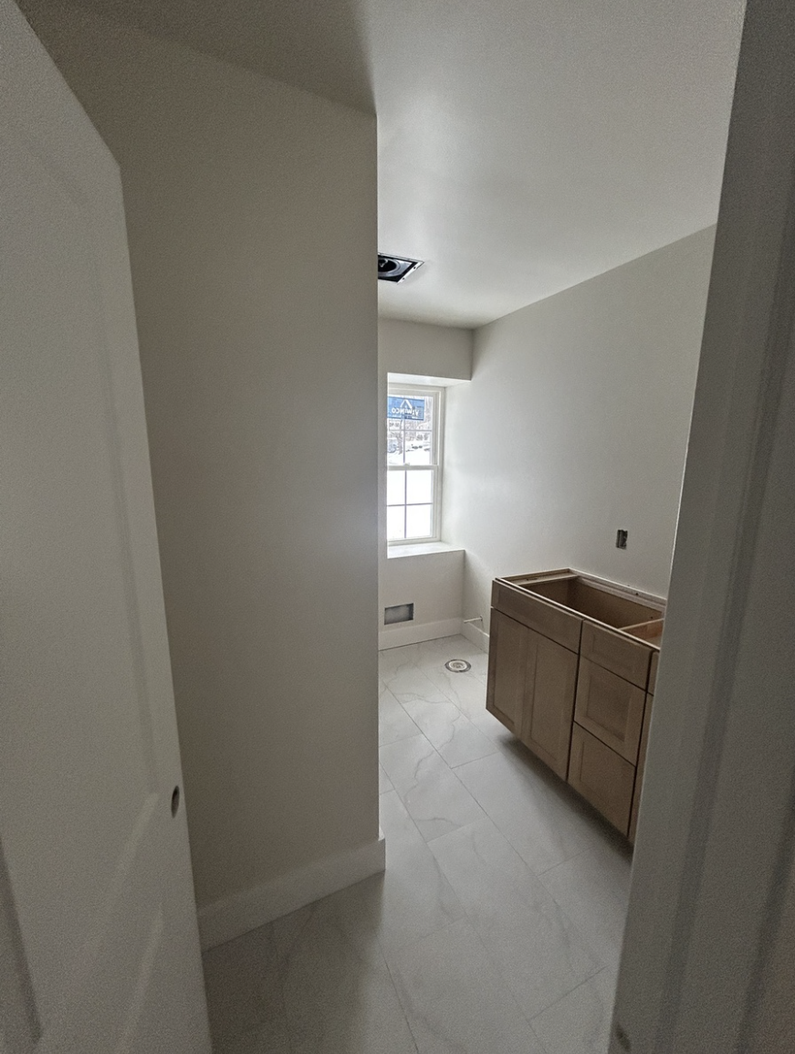 Empty bathroom with fresh paint and a cabinet with no countertop