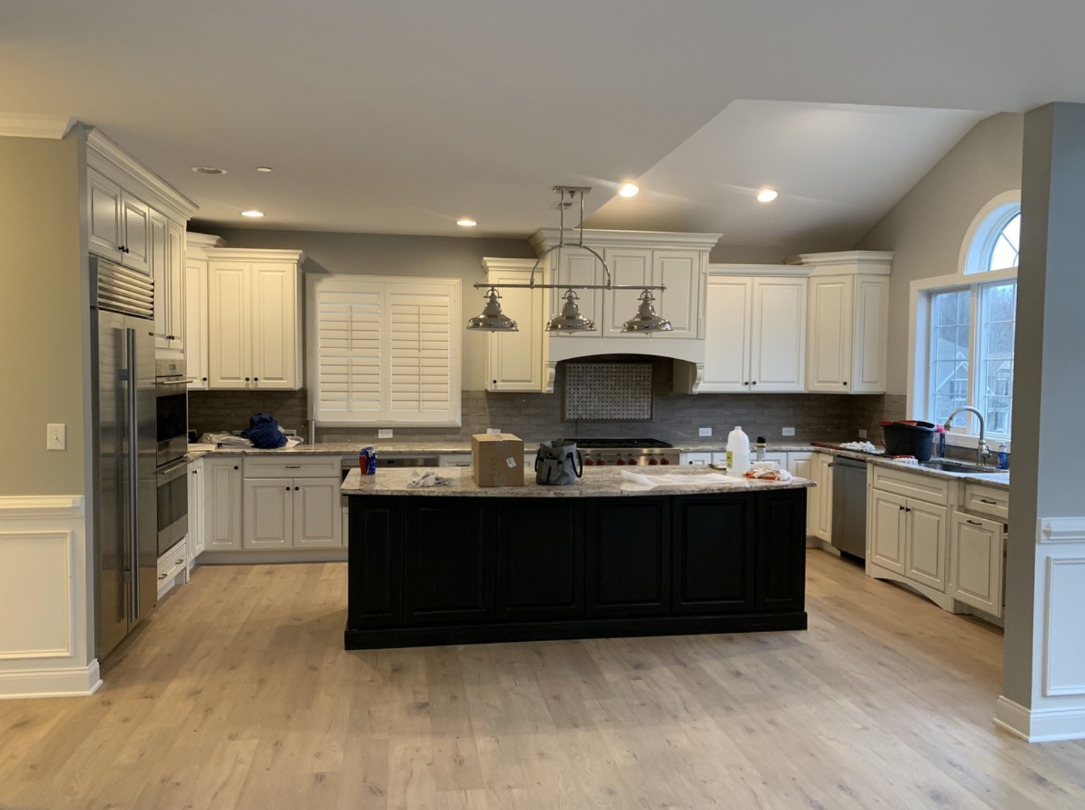 Open concept kitchen with island after fresh teal paint with white accents