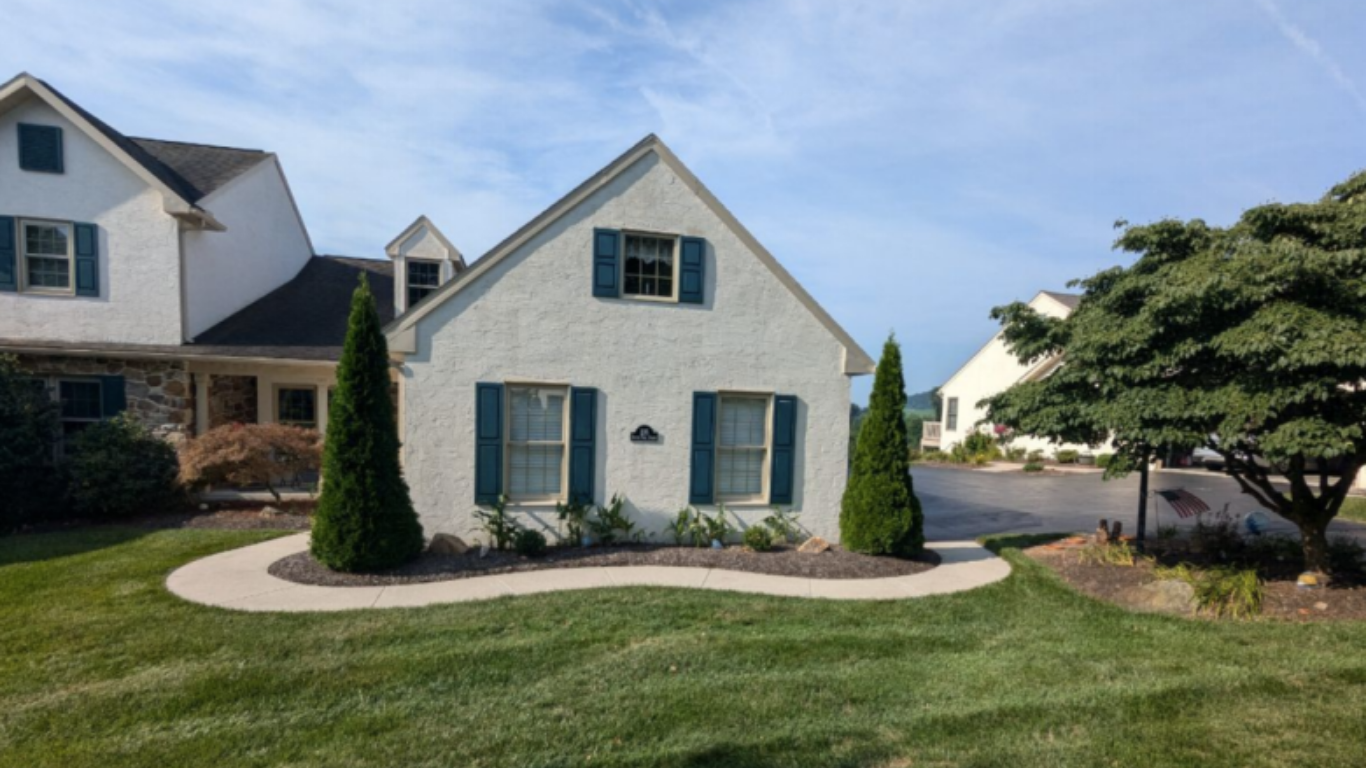 Split level home with off white stucco and blue window shutters