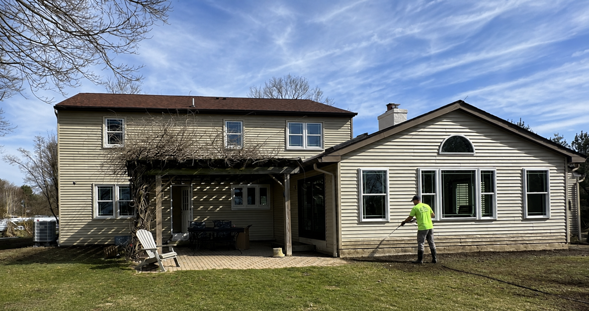 Van Horn Painting expert pressure washing split level home with beige siding