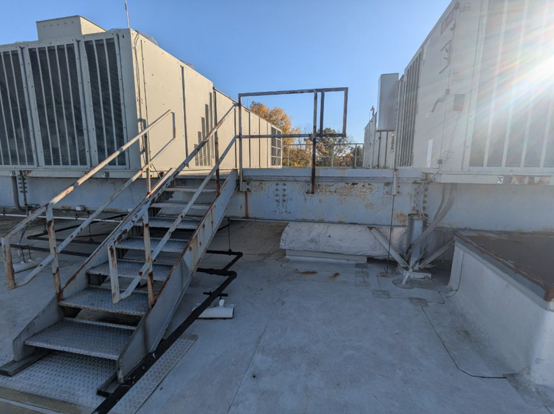Metal staircase on rooftop showing rust and needing painting services